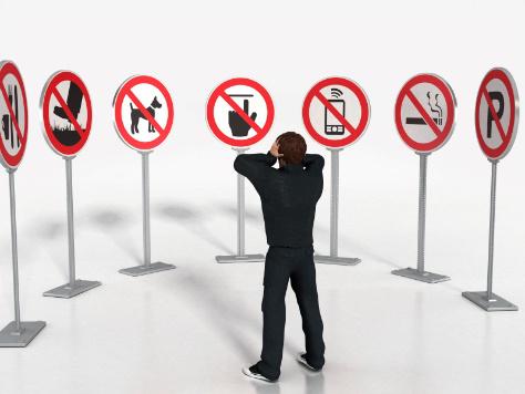 Man with hands on head,surronded by do not do signs